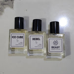 Three small rectangular perfume bottles with black caps and white labels reading ICE CUBE, REBEL, and BEAST, arranged on a light surface.3